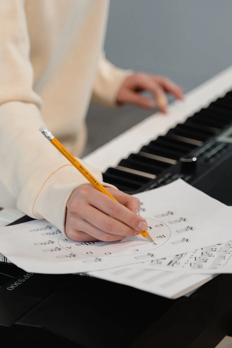 Creating music sheets while playing piano. Perfect for education and creativity themes.