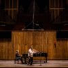 man playing grand piano on stage