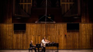 man playing grand piano on stage